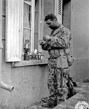 July 1944, U.S. soldier wearing a two-piece herringbone twill (HBT) camouflage which was used by marines in the Pacific, but was quickly abandoned in the European theater because of the similarity to the uniform of the Waffen SS