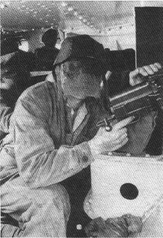 Танкист-пулеметчик в комбинезоне, самодельном кожаном противоударном шлеме и кольчужной маске.